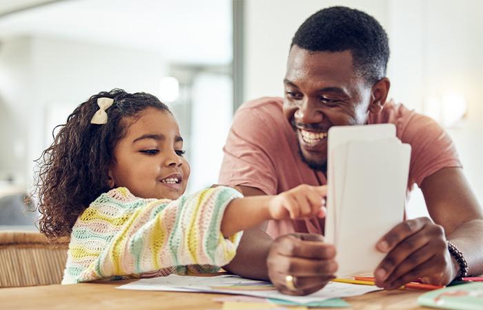 a man helps a young child with flash cards